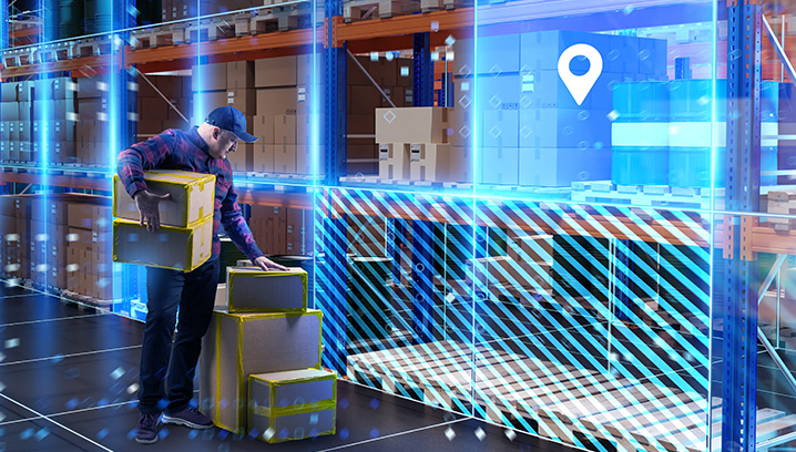 Lagerarbeiter hebt Kartons in einer modernen Lagerhalle, umgeben von Regalen und einem technischen Ambiente.