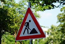 privater Versicherungsbereich: ein Warnschild für Bauarbeiten im Grünen