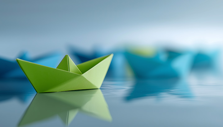 Ein grünes Origami-Boot schwimmt ruhig im Wasser, umgeben von blauen Booten, friedliche Stimmung.