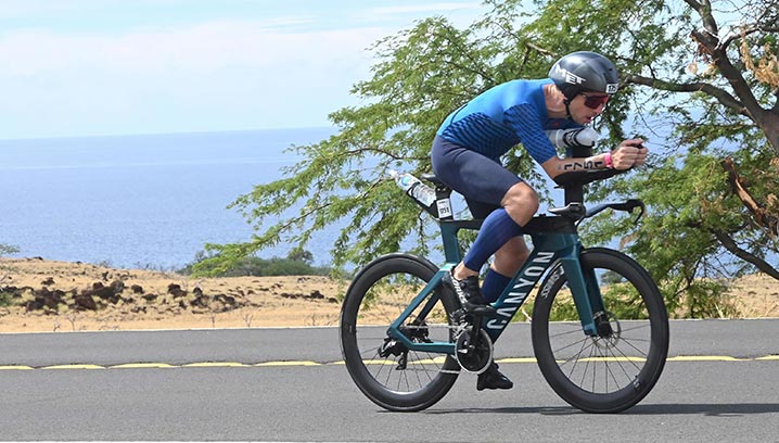 Alexander Funk fährt konzentriert an einer Küste entlang, umgeben von grüner Vegetation.