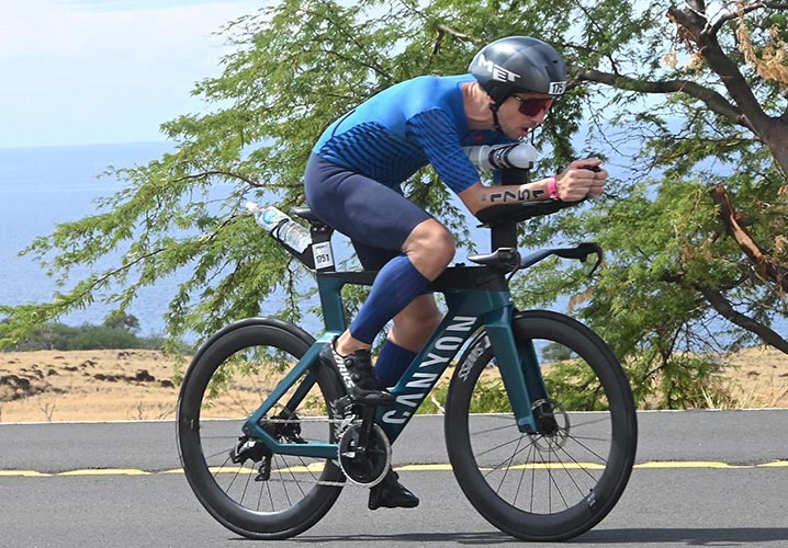 Alexander Funk fährt konzentriert an einer Küste Hawaiis entlang, umgeben von grüner Vegetation.
