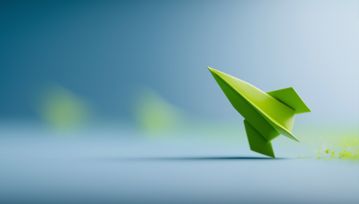 Eine grüne Origami Rakete startet vor unscharfem, sanften Hintergrund, vermittelt einen Eindruck von Freiheit und Kreativität.