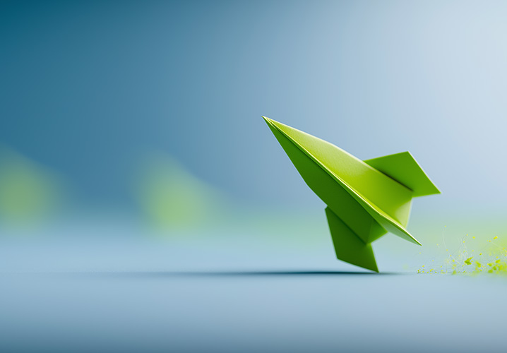 Eine grüne Origami Rakete startet vor unscharfem, sanften Hintergrund, vermittelt einen Eindruck von Freiheit und Kreativität.