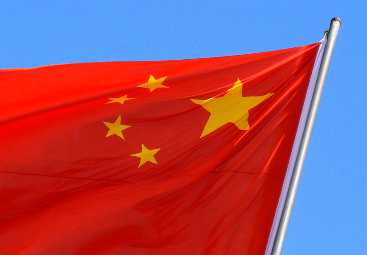 Flagge Chinas weht unter klarem Himmel, symbolisiert Nationalstolz und kulturelle Identität.