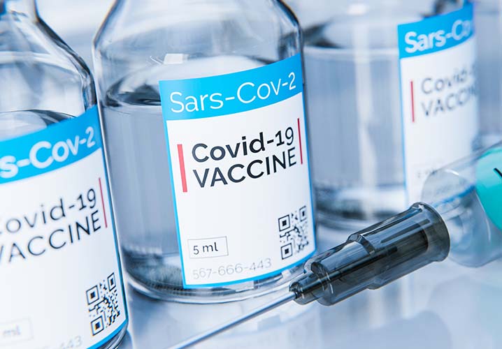 Corona Impfstoff gegen Covid-19 Flasche mit Spritze in Labor oder Krankenhaus