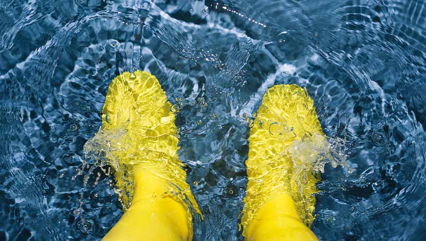 Gelbe Gummistiefel im Wasser