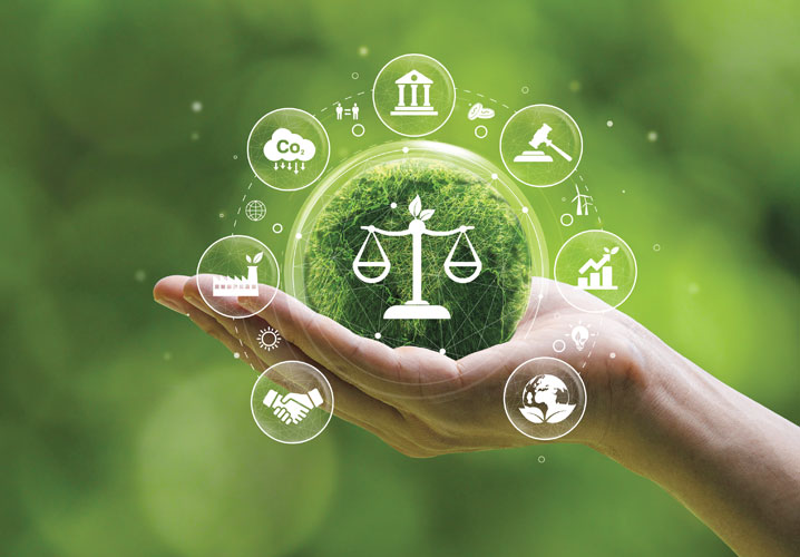 Eine Hand hält einen grünen Globus. Auf dem Globus ist das Symbol einer Waage, was das Gesetz symbolisiert. Um den Globus kreisen verschiedene Symbole mit Bezug auf Strafrecht, Nachhaltigkeit, Industrie und Umwelt, was Bezug auf das Thema Strafrechtsschutz nimmt.
