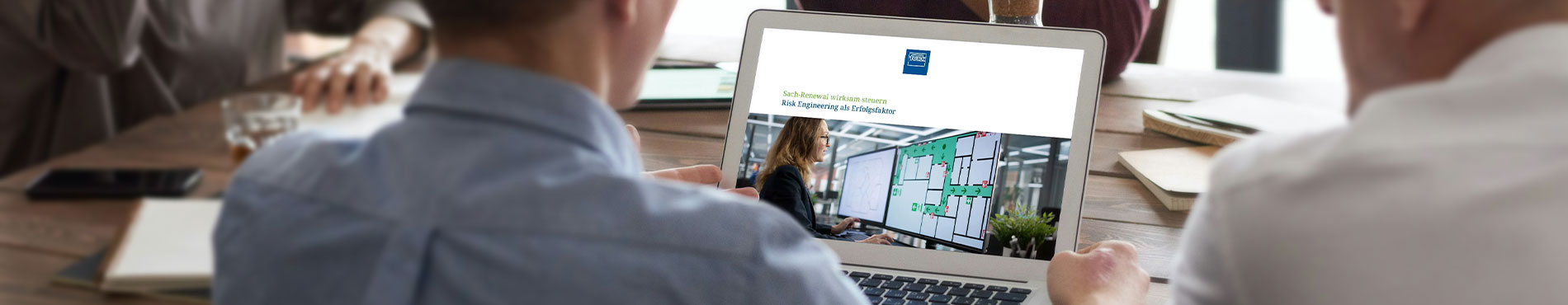 Person betrachtet auf einem Laptop die Broschüre „Sach-Renewal wirksam steuern – Risk Engineering als Erfolgsfaktor“ mit einer Risk-Engineering-Grafik auf dem Bildschirm.  