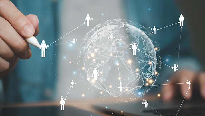 Hand mit Stift verbindet Menschen über eine digitale Weltkugel. Innovative, vernetzte Zukunftsstimmung.