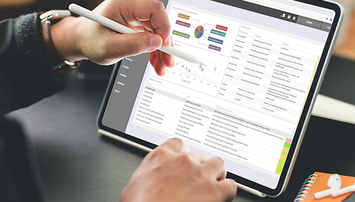 Eine Hand hält einen Stift und navigiert auf einem Tablet mit Datenanalyse-Software, die Effizienz ausstrahlt.