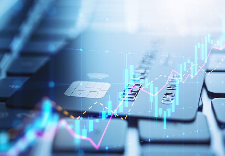 Nahaufnahme einer Kreditkarte auf einer Tastatur, mit Finanzdiagrammen, die Dynamik und Technologie ausstrahlen.