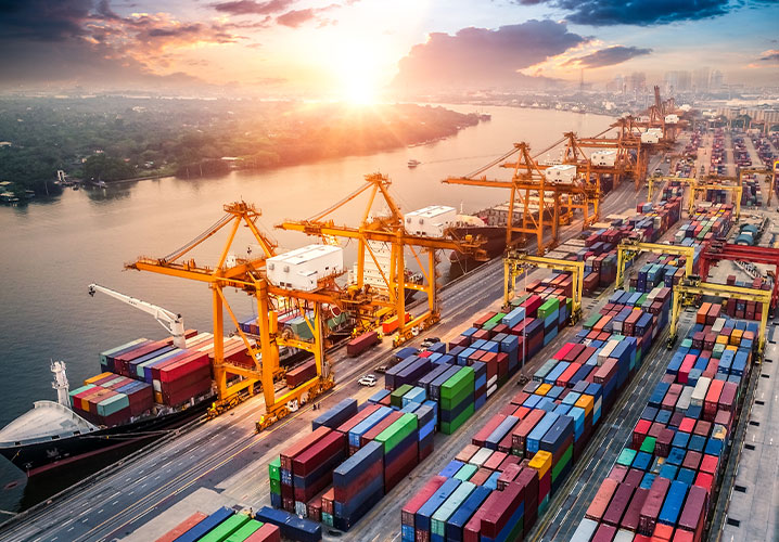 Hafen mit Containerschiffen und Kräne, Sonnenuntergang reflektiert eine geschäftige, dynamische Atmosphäre.